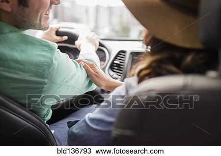 Stock Image - Couple driving together in car. Fotosearch