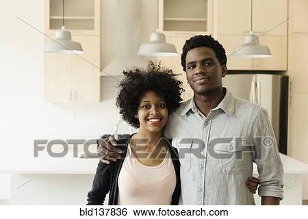 Couple hugging in kitchen in new house View Large Photo Image Stock Photograph - Couple hugging in kitchen in new house. Fotosearch
