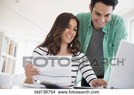 Picture - Couple paying bills together online. Fotosearch