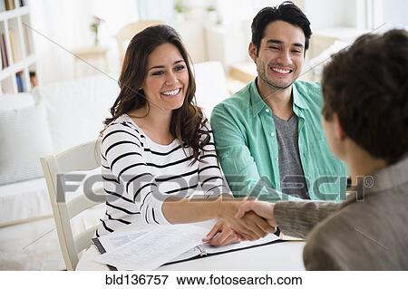 Stock Photo - Couple shaking hands with financial adviser. Fotosearch