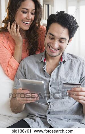 Stock Image - Couple shopping together on tablet computer. Fotosearch