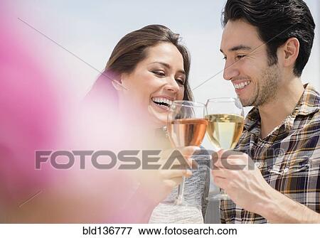 Stock Photo - Couple toasting each other with wine. Fotosearch