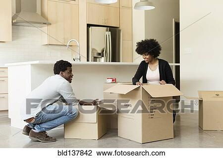 Couple unpacking cardboard box in new house View Large Photo Image Stock Image - Couple unpacking cardboard box in new house. Fotosearch
