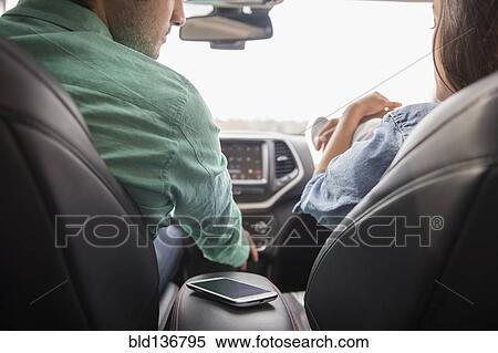 Couple with cell phone in car View Large Photo Image Stock Photography - Couple with cell phone in car. Fotosearch