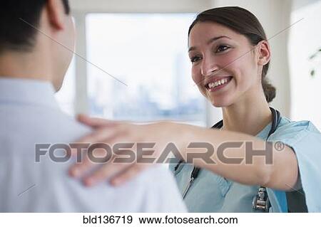 Stock Photo - Doctor and nurse hugging in office. Fotosearch