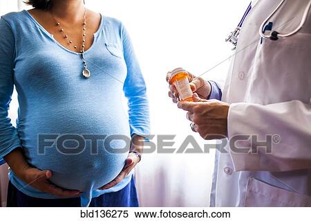 Stock Photography - Doctor giving pregnant woman prescription medicine. Fotosearch