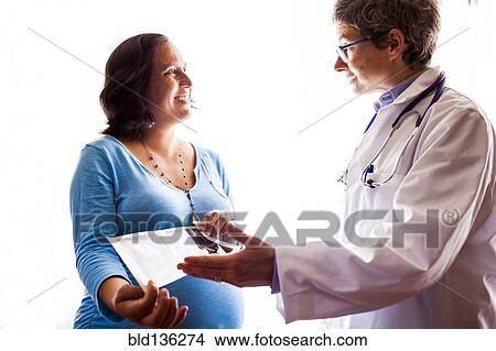 Picture - Doctor talking to pregnant patient. Fotosearch
