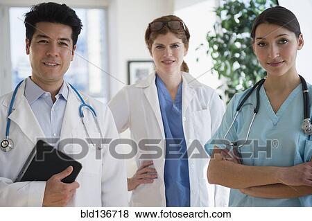 Stock Photo - Doctors and nurse smiling in office. Fotosearch