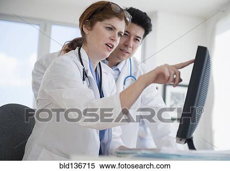 Doctors using touch screen computer in office View Large Photo Image Stock Photography - Doctors using touch screen computer in office. Fotosearch