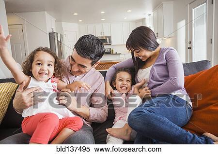Stock Photography - Family playing together on sofa. Fotosearch