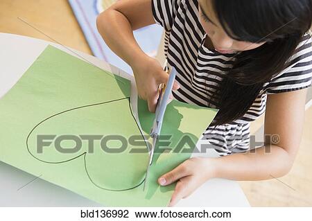 Filipino girl cutting heart shape out of paper View Large Photo Image Stock Image - Filipino girl cutting heart shape out of paper. Fotosearch