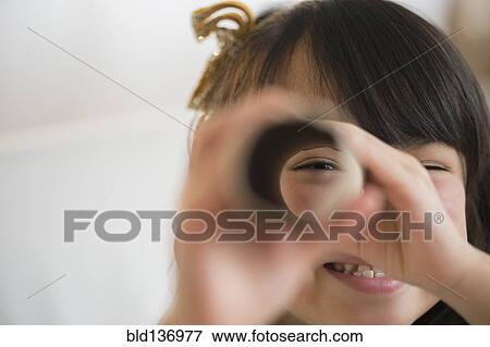 Stock Photo - Filipino girl looking through cardboard tube. Fotosearch