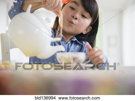 Picture - Filipino girl pouring tea. Fotosearch