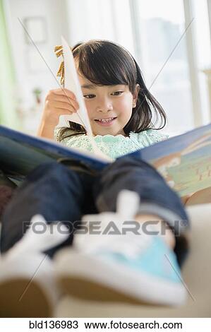 Filipino girl reading book on sofa View Large Photo Image Stock Image - Filipino girl reading book on sofa. Fotosearch