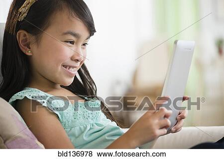 Stock Photo - Filipino girl using tablet computer. Fotosearch