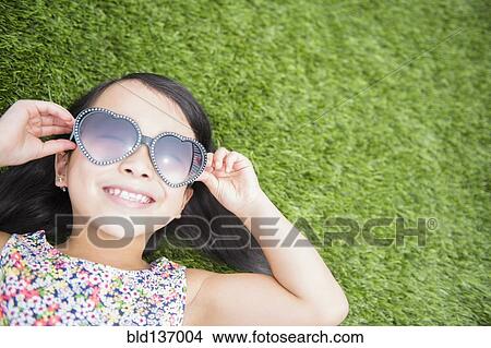 Picture - Filipino girl wearing sunglasses in backyard. Fotosearch