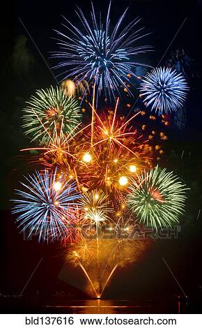 Stock Photograph - Fireworks exploding over cruise ship in harbor, Seattle, Washington, United States. Fotosearch