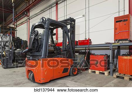 Forklift machinery and shelves in warehouse View Large Photo Image Picture - Forklift machinery and shelves in warehouse. Fotosearch
