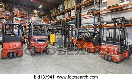 Stock Image - Forklift machinery in a row in warehouse. Fotosearch