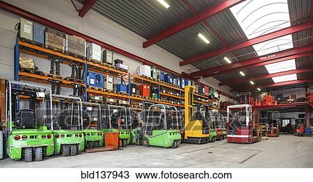 Stock Image - Forklift machinery in a row in warehouse. Fotosearch