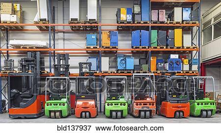 Forklift machinery in a row in warehouse View Large Photo Image Stock Photo - Forklift machinery in a row in warehouse. Fotosearch
