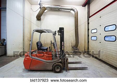 Stock Image - Forklift machinery parked in warehouse. Fotosearch