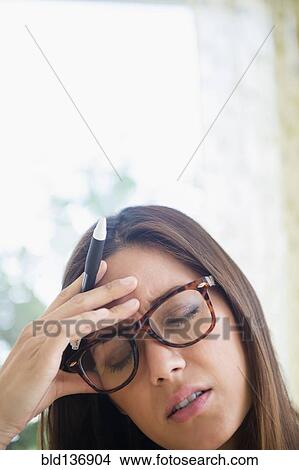 Picture - Frustrated woman rubbing her forehead. Fotosearch