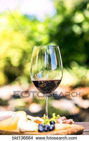 Picture - Glass of wine with cheese and meat board. Fotosearch