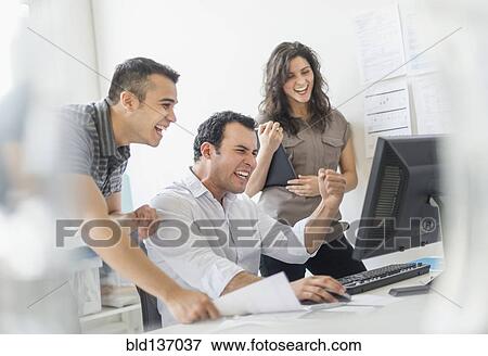 Stock Photo - Hispanic business people cheering together in office. Fotosearch