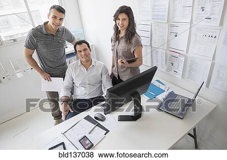 Stock Photo - Hispanic business people smiling in office. Fotosearch