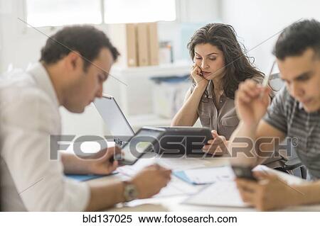 Hispanic business people using technology in office View Large Photo Image Stock Photography - Hispanic business people using technology in office. Fotosearch