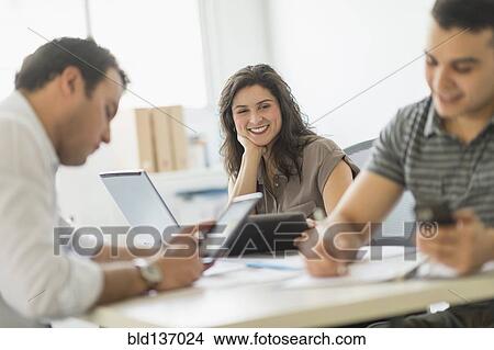 Picture - Hispanic business people working in office. Fotosearch