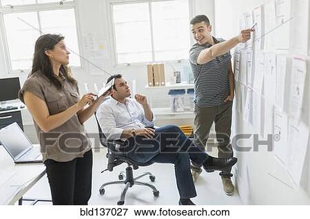 Stock Photo - Hispanic business people working together in office. Fotosearch