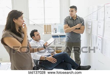 Stock Photo - Hispanic business people working together in office. Fotosearch