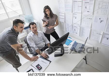 Stock Photo - Hispanic business people working together in office. Fotosearch