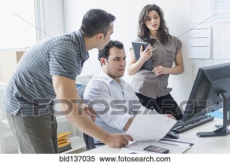Stock Photography - Hispanic business people working together in office. Fotosearch