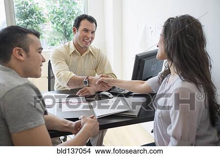 Hispanic businessman shaking hands with client in office View Large Photo Image Picture - Hispanic businessman shaking hands with client in office. Fotosearch