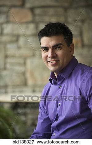 Stock Photo - Hispanic businessman sitting indoors. Fotosearch