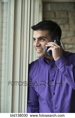 Stock Image - Hispanic businessman talking on cell phone. Fotosearch