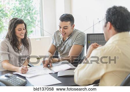 Hispanic businessman talking to clients in office View Large Photo Image Stock Photo - Hispanic businessman talking to clients in office. Fotosearch
