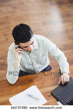 Hispanic businessman working at desk View Large Photo Image Stock Photography - Hispanic businessman working at desk. Fotosearch