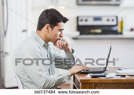 Picture - Hispanic businessman working at home. Fotosearch