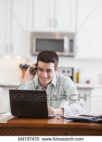 Stock Photography - Hispanic businessman working at home. Fotosearch
