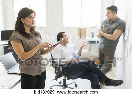Stock Photo - Hispanic businesswoman using tablet computer in office. Fotosearch