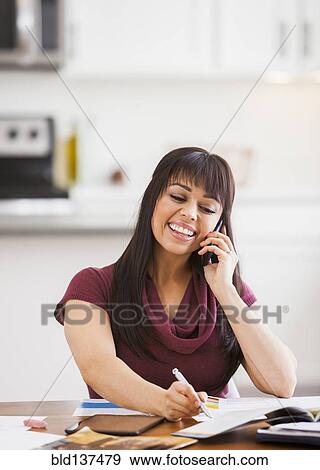Stock Photo - Hispanic businesswoman working at home. Fotosearch