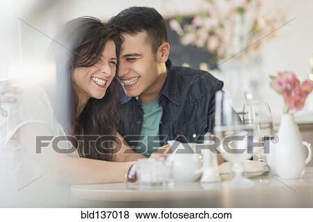 Hispanic couple laughing in cafe View Large Photo Image Stock Photo - Hispanic couple laughing in cafe. Fotosearch