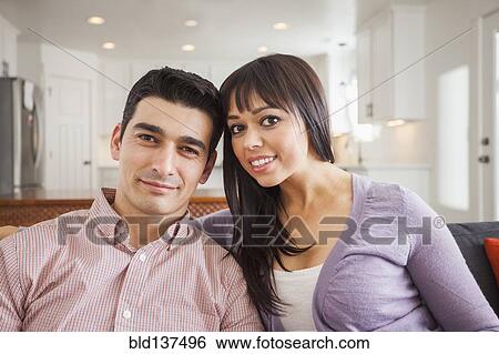 Stock Photograph - Hispanic couple relaxing on sofa. Fotosearch