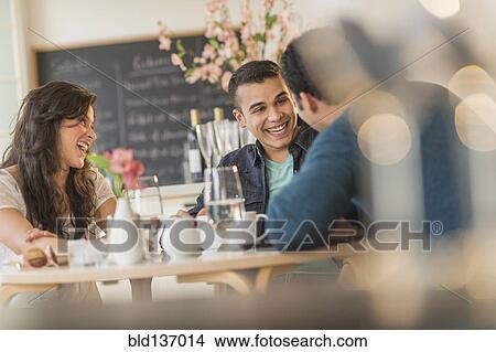 Picture - Hispanic friends talking in cafe. Fotosearch