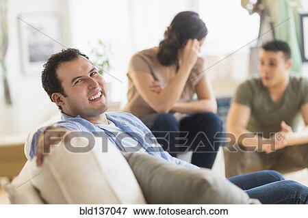 Hispanic man smiling on sofa View Large Photo Image Stock Photo - Hispanic man smiling on sofa. Fotosearch