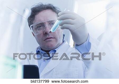 Hispanic scientist examining test tube in lab View Large Photo Image Stock Photo - Hispanic scientist examining test tube in lab. Fotosearch